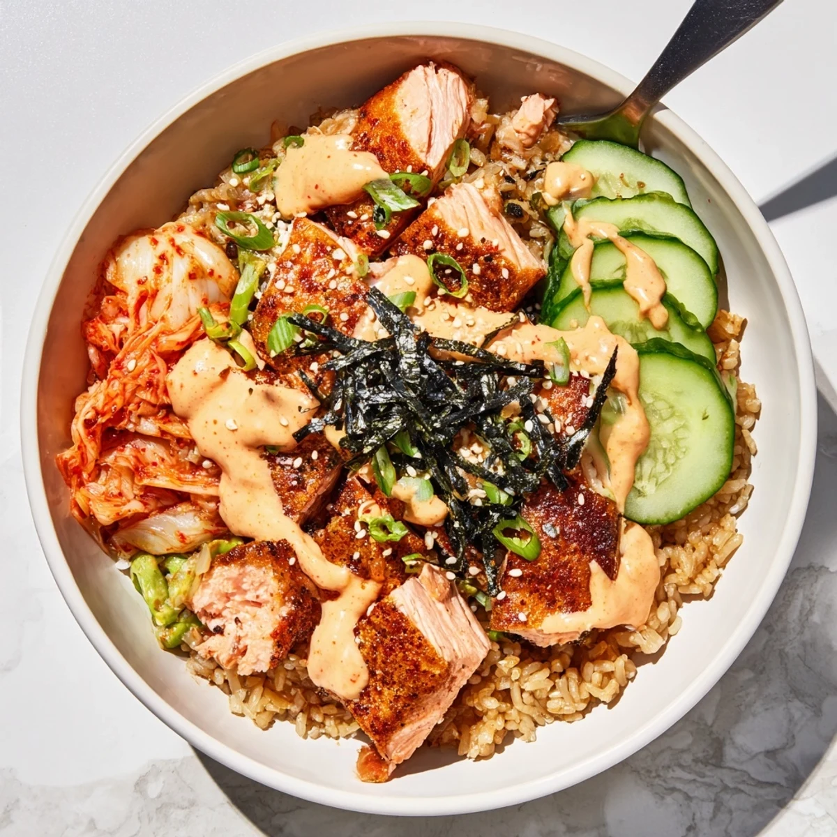 Deliciously layered crispy salmon rice bowl featuring creamy avocado and garlic crunch.  