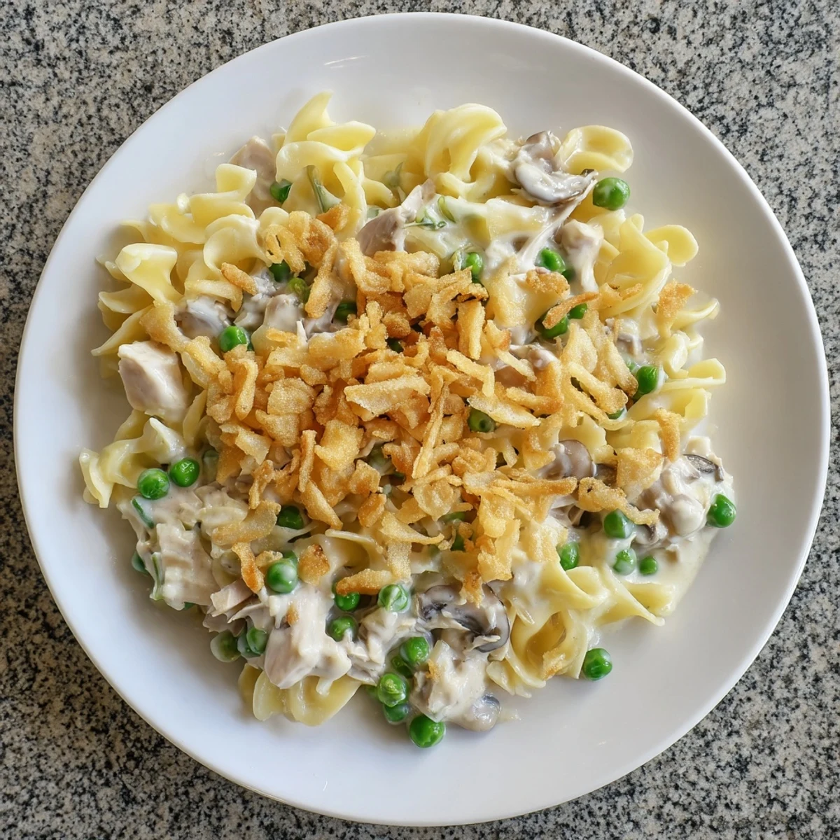 A close-up of a bubbling tuna noodle casserole, showcasing creamy sauce and golden crust.