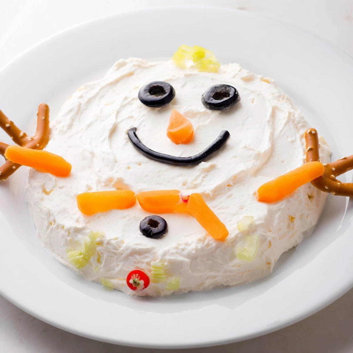 Whimsical Melted Snowman Dip Bowl, loaded with olives and carrot, ready to be scooped up.
