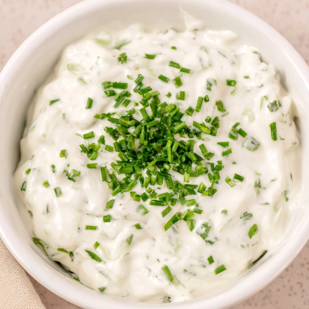Creamy Veggie Ranch Dip topped with green chives and served with colorful fresh vegetables.
