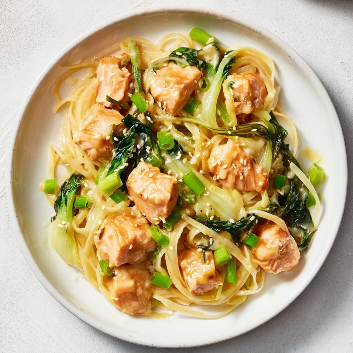 Savory Miso Butter Salmon Pasta: a comforting fusion meal garnished with fresh scallions and sesame seeds.