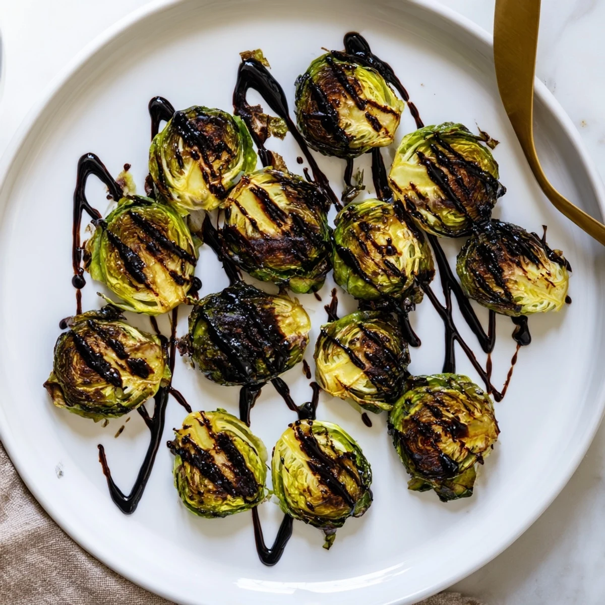 Golden roasted Brussels sprouts glistening with a sticky balsamic glaze on a rustic platter.