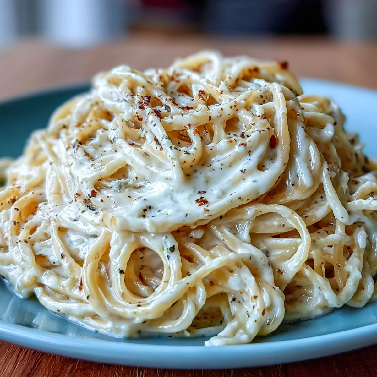 A rustic white bowl of Cacio e Pepe, topped with extra Pecorino Romano, ready to be enjoyed with a glass of white wine.