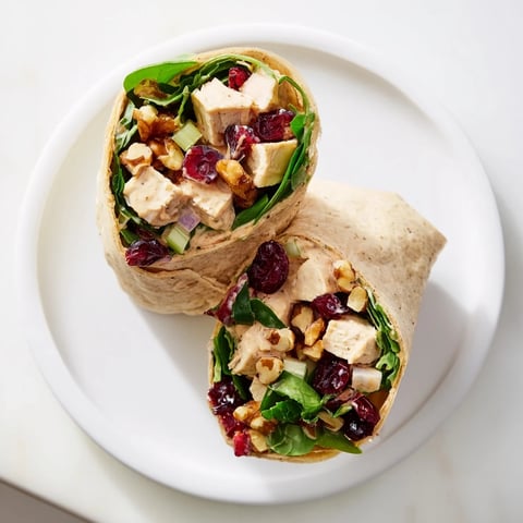 Festive Cranberry Pecan Chicken Salad Christmas Wrap, overflowing with juicy chicken and crunchy pecans.