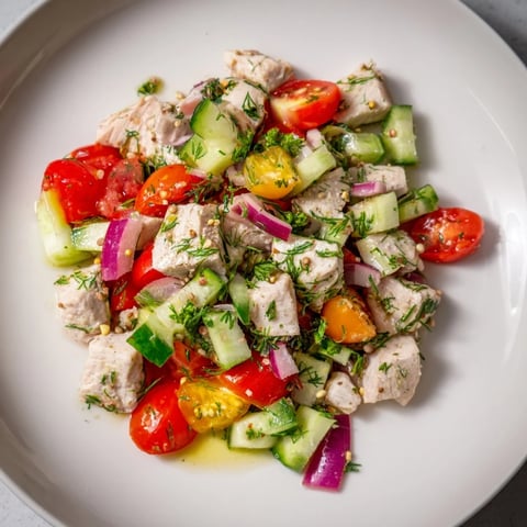 Close-up of fresh Cucumber and Chicken Clean Shaker salad, vibrant with herbs and a zesty dressing.