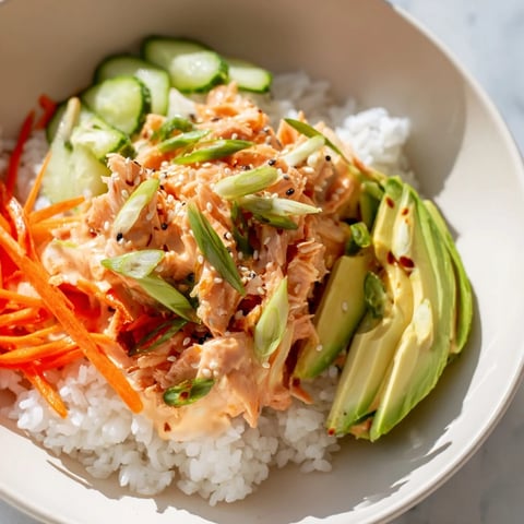 Steaming bowl of Spicy Canned Salmon Rice Bowl with colorful veggies, ready for a flavorful bite.