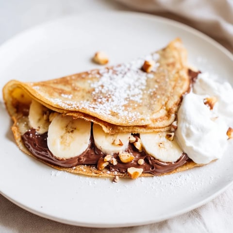Golden banana Nutella wrap, neatly folded and crispy, ready to serve with whipped cream.