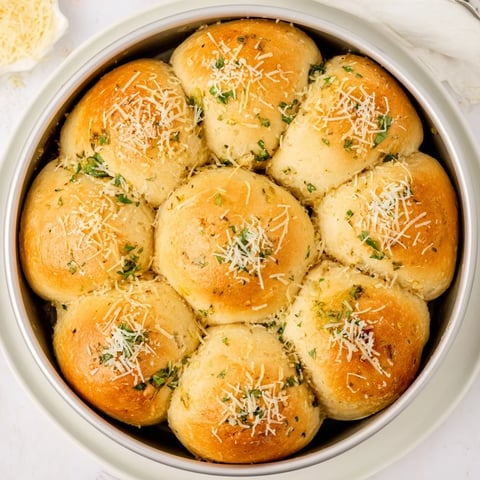 Freshly baked Garlic Butter Bread Pull-Apart rolls in a skillet, showcasing golden, buttery edges and soft, fluffy centers infused with minced garlic and parsley.