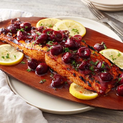 Beautiful, glazed Western Fresh Cedar Plank Salmon rests on smoky cedar, ready to serve.