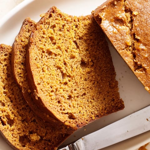 Spiced Pumpkin Bread recipe: a slice with cream cheese, ready for a cozy breakfast.