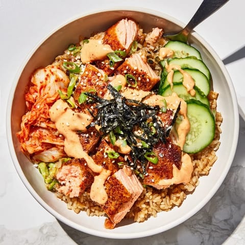 Deliciously layered crispy salmon rice bowl featuring creamy avocado and garlic crunch.  