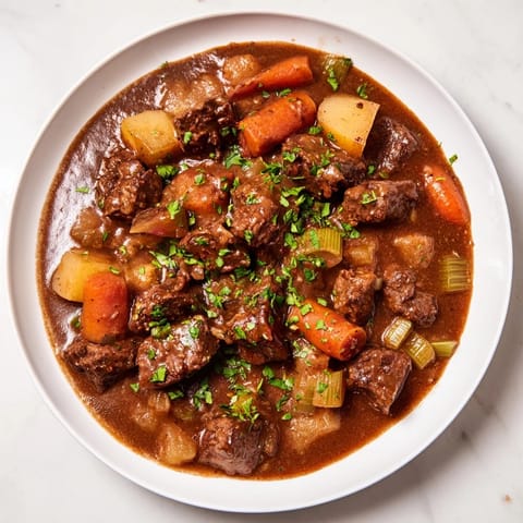 Hearty Instant Pot Beef Stew with tender beef and vegetables, garnished with fresh parsley for serving.