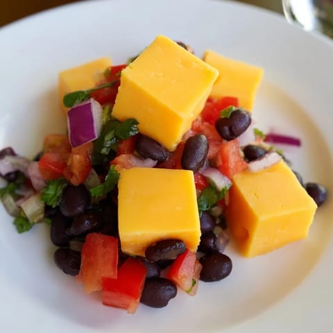 Vibrant black bean salsa alongside spicy Pepper Jack cheese cubes, perfect for a party snack.