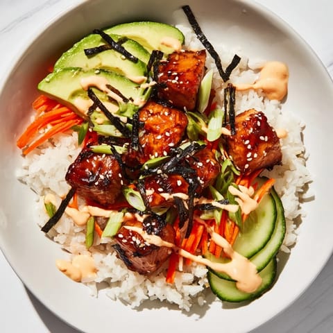 A close-up of a delicious teriyaki salmon rice bowl, showcasing glazed salmon and fluffy rice.