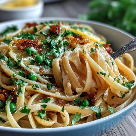 Vibrant lemon butter pasta with peas and Parmesan, a creamy spring dish with bright citrus notes and tender green vegetables.