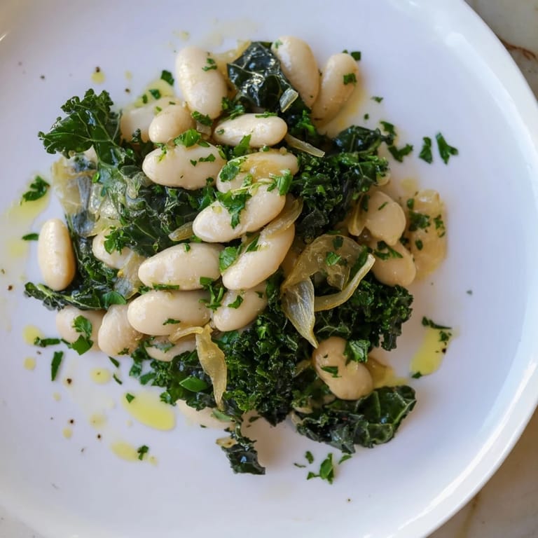 Vibrant plate of Garlicky Beans with Winter Greens, drizzled with olive oil and fresh parsley for flavor.