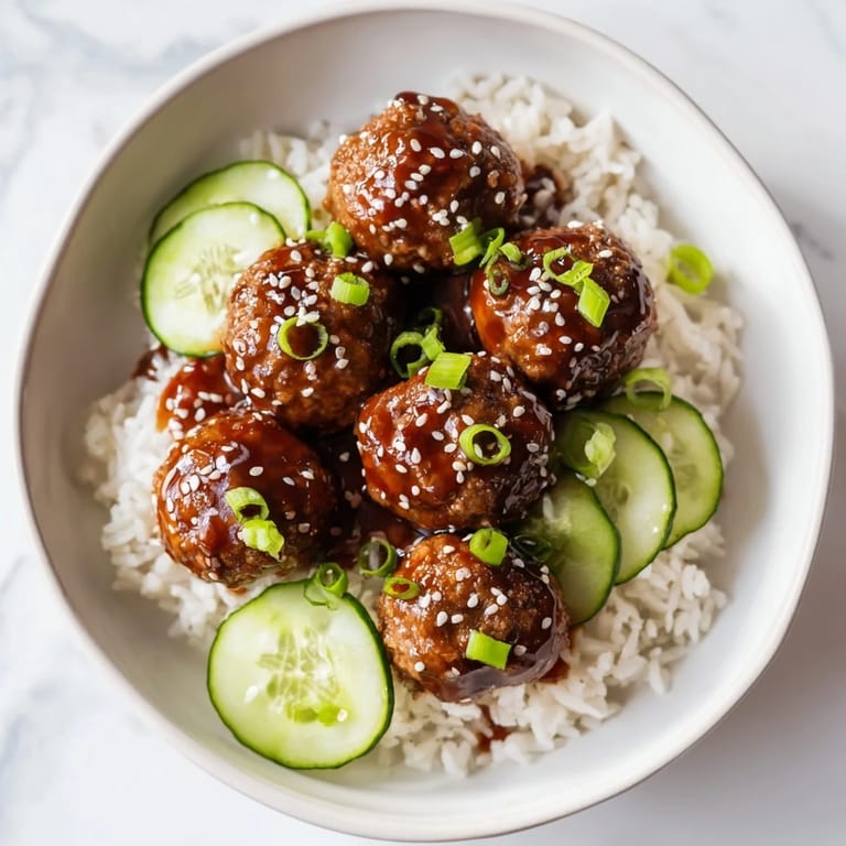 Tender teriyaki meatball bowls with cucumber slices, providing a burst of refreshing flavor and texture.