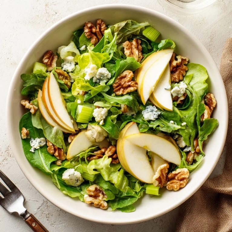Golden apple wedges and toasted walnuts mingle over mixed greens, topped with crumbled blue cheese for a savory bite.