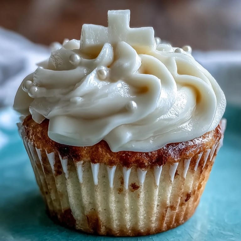 Enjoy tender Communion cupcakes frosted smooth, topped with a pure white fondant cross detail.
