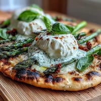 Roasted asparagus flatbread with creamy burrata and bright lemon zest topping.